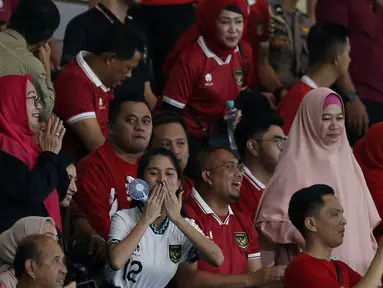 Momen Azizah Salsha (tengah bawah) saat memberikan isyarat cinta berupa kecupan jauh kepada suaminya, Pratama Arhan, yang merupakan bek Timnas Indoneisa U-23 setelah mencetak gol ke gawang Turkmenistan dalam pertandingan grup K Kualifikasi Piala Asia U-23 2024 yang berlangsung di Stadion Manahan, Solo, Selasa (12/9/2023). (Bola.com/Arief Bagus)