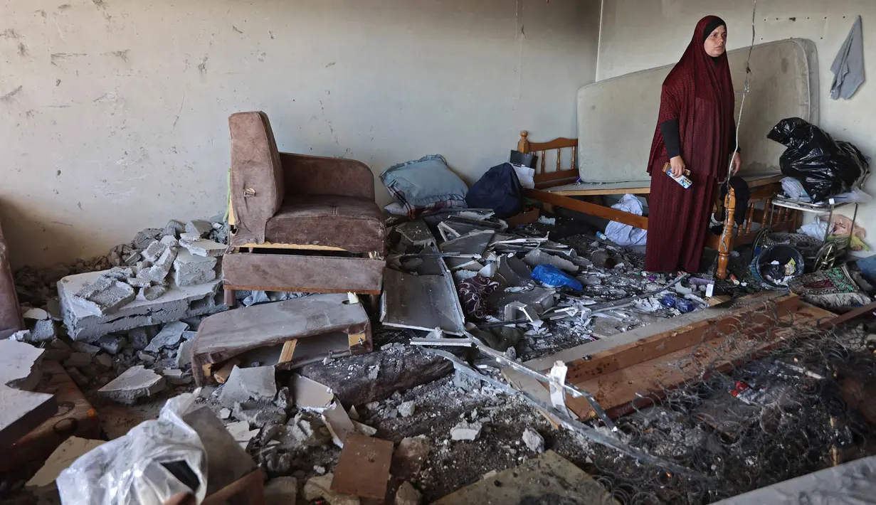 Seorang wanita Palestina berdiri di tengah reruntuhan bangunan tempat tinggal yang rusak setelah serangan Israel di Kota Gaza pada Kamis 4 Juni 2026. (Omar AL-QATTAA/AFP)