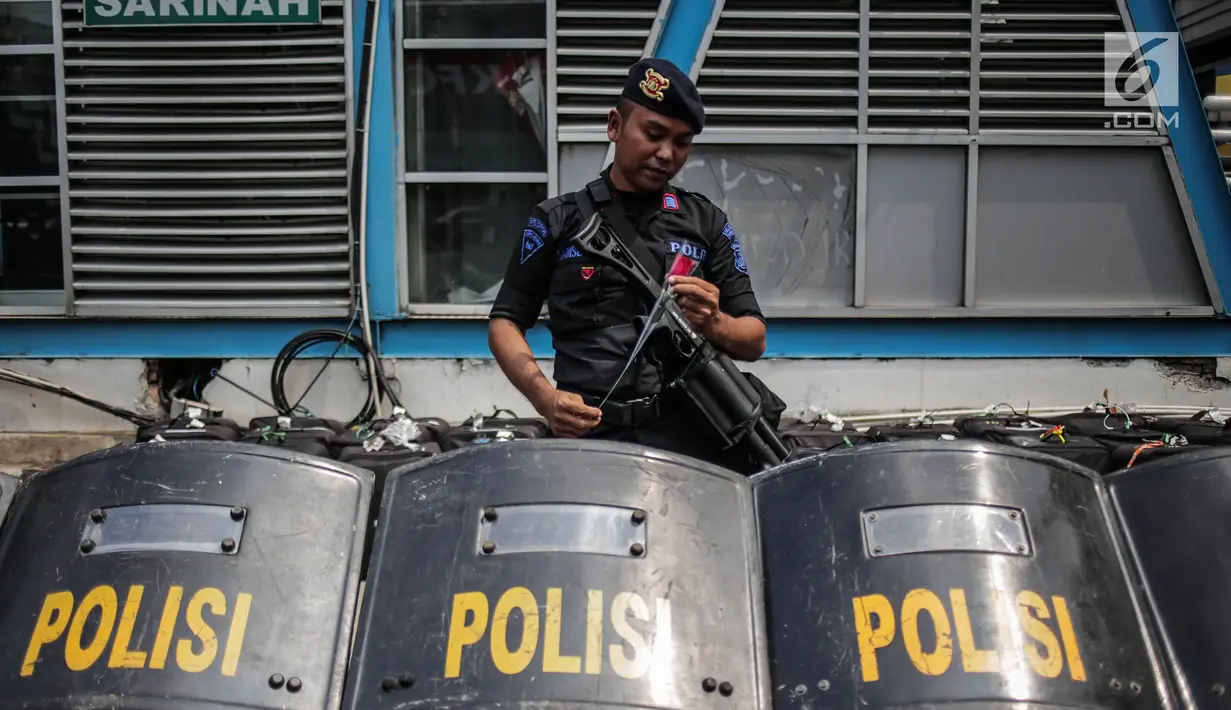 Petugas Brimob menerima bunga dari peserta aksi komunitas Spartan Nusantara di sekitar Gedung Bawaslu, Jakarta, Minggu (26/5/2019). Aksi tersebut sebagai bentuk terima kasih kepada TNI/Polri karena setia dan menjaga keamanan NKRI terkait sengketa pemilu. (Liputan6.com/Faizal Fanani)