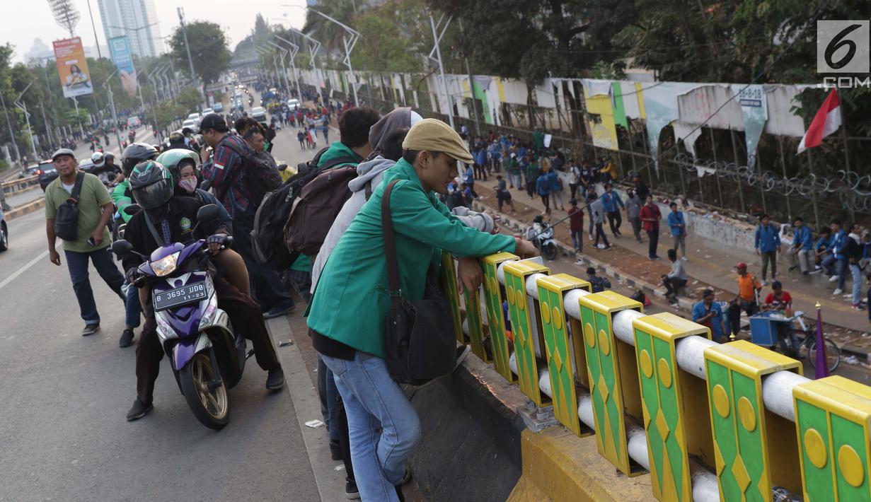 Warga berkerumun menyaksikan aksi unjuk rasa yang dilakukan mahasiswa dari berbagai perguruan tinggi di sekitar Jembatan Layang Gerbang Pemuda, Jakarta, Selasa (1/10/2019). Mahasiswa dari berbagai perguruan tinggi kembali berunjuk rasa menolak beberapa RUU. (Liputan6.com/Helmi Fithriansyah)