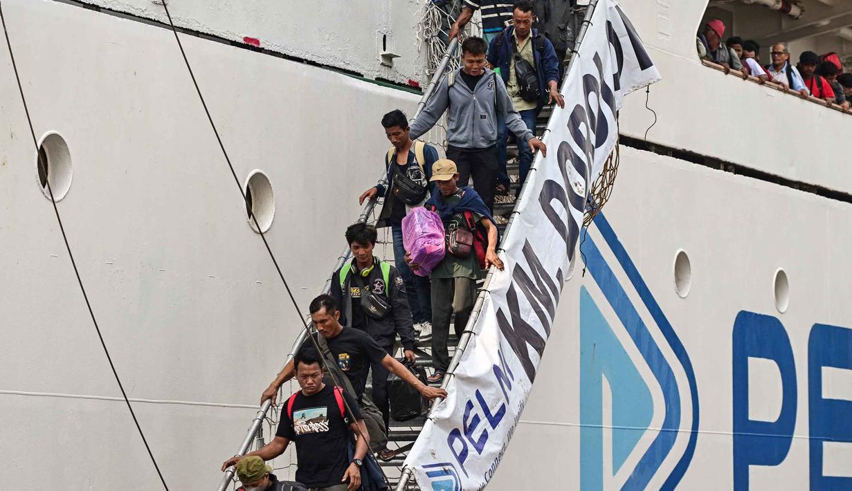 Sementara untuk puncak arus mudik Lebaran 2026 di Pelabuhan Tanjung Perak, Surabaya, diperkirakan terjadi dalam dua periode, antara tanggal 13 hingga 18 Maret 2026. Tampak dalam foto, para penumpang berjalan keluar untuk turun dari kapal di pelabuhan Perak, Surabaya, Jawa Timur pada Minggu 15 Maret 2026. (JUNI KRISWANTO/AFP)