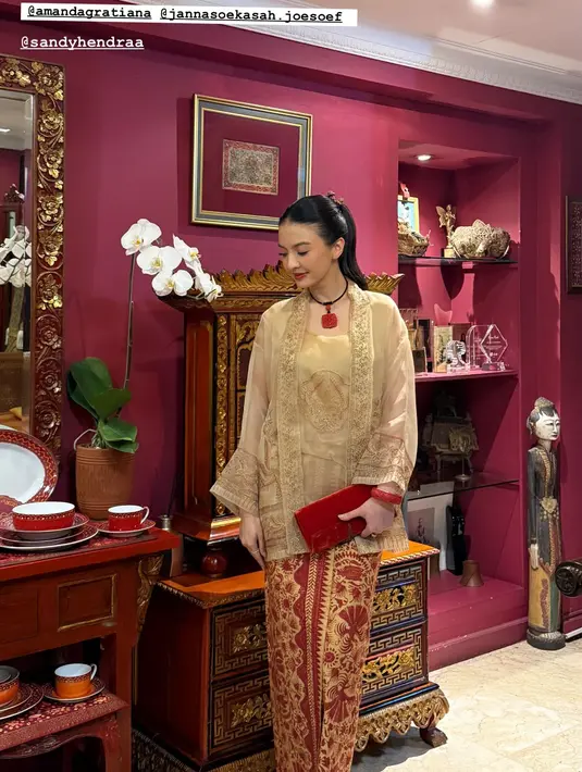 Tanpa kebaya encim, Raline Shah tampil dengan kebaya kutubaru bergaya peranakan warna gold. Dipadu dengan kain Batik merah gold dan clutch merah [@ralineshah]