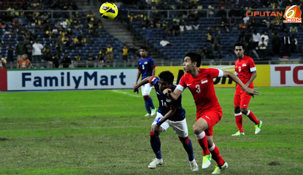 Pemain Timnas Malaysia, Muhymeen bin Zambri (kiri) dan pemain Singapura, Mohamad Shaiful (kanan) duel mendapatkan bola dalam Laga Piala AFF Suzuki 2012 di Stadion Bukit Jalil, Kuala Lumpur, Malaysia, minggu 25 November 2012. pertandingan berakhir 0-3 untu