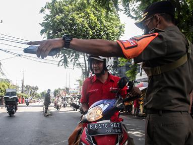 Petugas mengarahkan pengendara motor saat Razia Protokol Kesehatan di kawasan Kebayoran Lama, Jakarta, Selasa (19/10/2021). Razia PPKM Level 3 kerap dilakukan demi memutus rantai penyebaran covid 19, dengan sanksi denda Rp 100.000 dan sanksi sosial seperti menyapu jalan. (Liputan6.com/Johan Tallo)