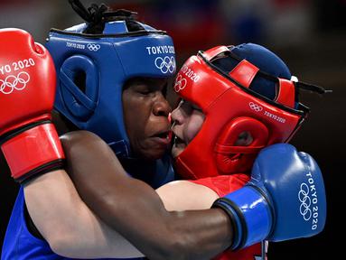 Petinju asal Jepang Tsukimi Namiki (kanan) bertarung dengan Catherine Nanziri asal Uganda dalam pertandingan tinju kelas terbang putri pada Olimpiade Tokyo 2020 di Kokugikan Arena, Tokyo, Minggu (25/7/2021). (Foto: AFP/Various Source/Luis Robayo)