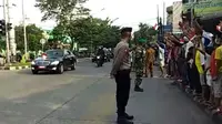 Warga Medan Sambut Kedatangan Jokowi dengan Lambaikan Bendera Merah Putih