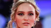 Aktris Lily-Rose Depp berpose setibanya di pemutaran perdana film 'The King' di Festival Film Venice edisi ke-76, Venice, Italia (2/9/2019). Putri aktor Johnny Depp ini tampil memesona berbalut gaun berwarna pink di karpet merah Venice Film Festival 2019. (AFP Photo/Alberto Pizzoli)