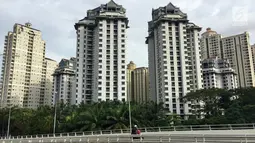 Seorang pengendara sepeda motor melintasi jembatan layang dengan latar belakang gedung apartemen yang berjajar di kawasan Kemayoran, Jakarta, Jumat (19/1). (Liputan6.com/Immanuel Antonius)