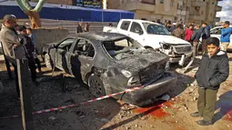 Warga melihat-lihat dampak kerusakan akibat serangan bom mobil ganda di Kota Benghazi, Libya, Rabu (24/1). Korban dari kedua peristiwa itu meliputi personel militer dan warga sipil. (AFP PHOTO/Abdullah DOMA)