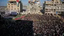 Warga berebut untuk bisa menyaksikan pernikahan tersebut, bahkan sampai memanjat reruntuhan bangunan, untuk menyaksikan upacara tersebut. Tampak dalam foto, warga Palestina menyaksikan dan merayakan upacara pernikahan massal di Kota Hamad, Khan Younis, Jalur Gaza, Selasa 2 Desember 2025. (AP Photo/Abdel Kareem Hana)