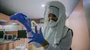 Dr. Maureen P. Ines-Manzano, seorang dokter gigi, mengenakan setelan respirator dengan pemurni udara di dalam kliniknya di Manila, Filipina, pada 19 Oktober 2020. Pasien Dr. Manzano menjulukinya "dokter gigi astronaut" karena mengenakan setelan PAPR utuk menghindari COVID-19. (Xinhua/Rouelle Umali)