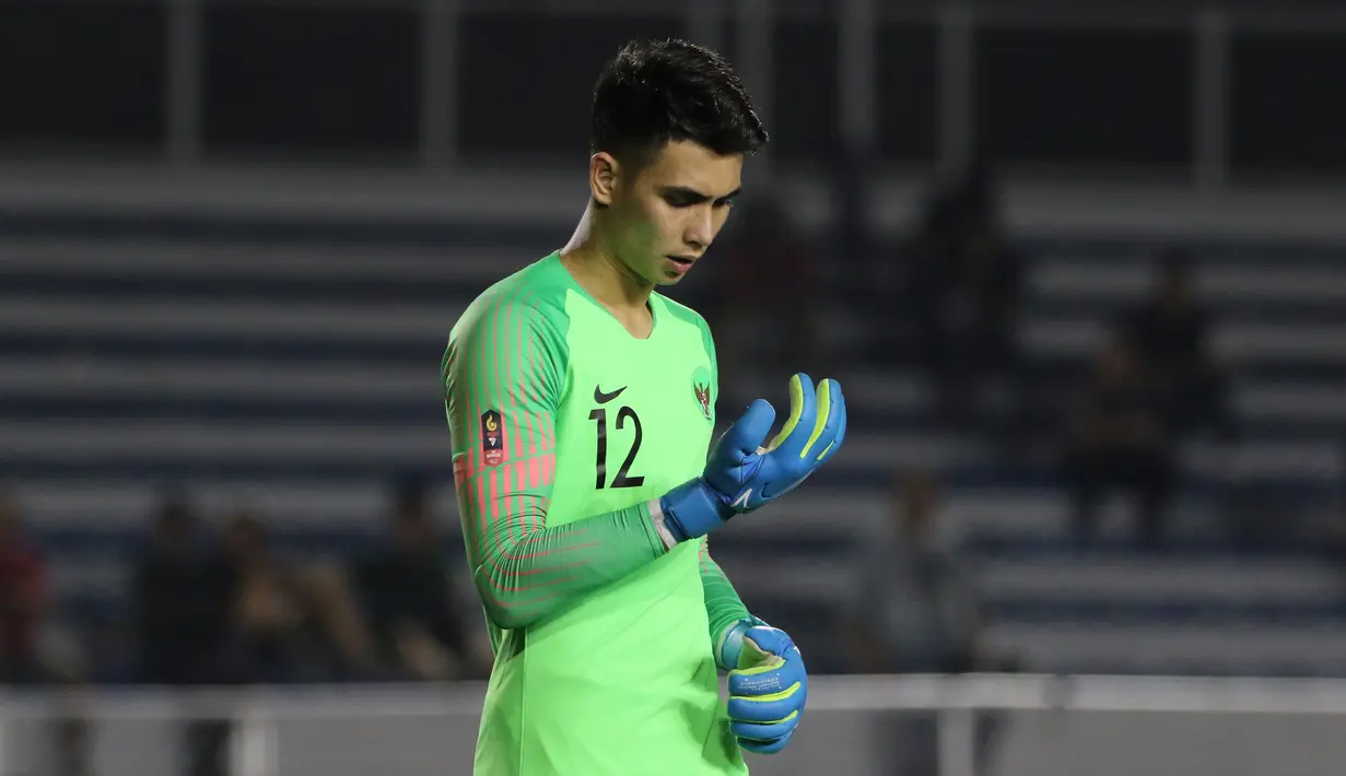 Kiper Timnas Indonesia U-22, Nadeo Argawinata, merapihkan sarung tangan saat melawan Singapura U-22 pada laga SEA Games 2019 di Stadion Rizal Memorial, Manila, Kamis (28/11). Indonesia menang 2-0 atas Singapura. (Bola.com/M Iqbal Ichsan)