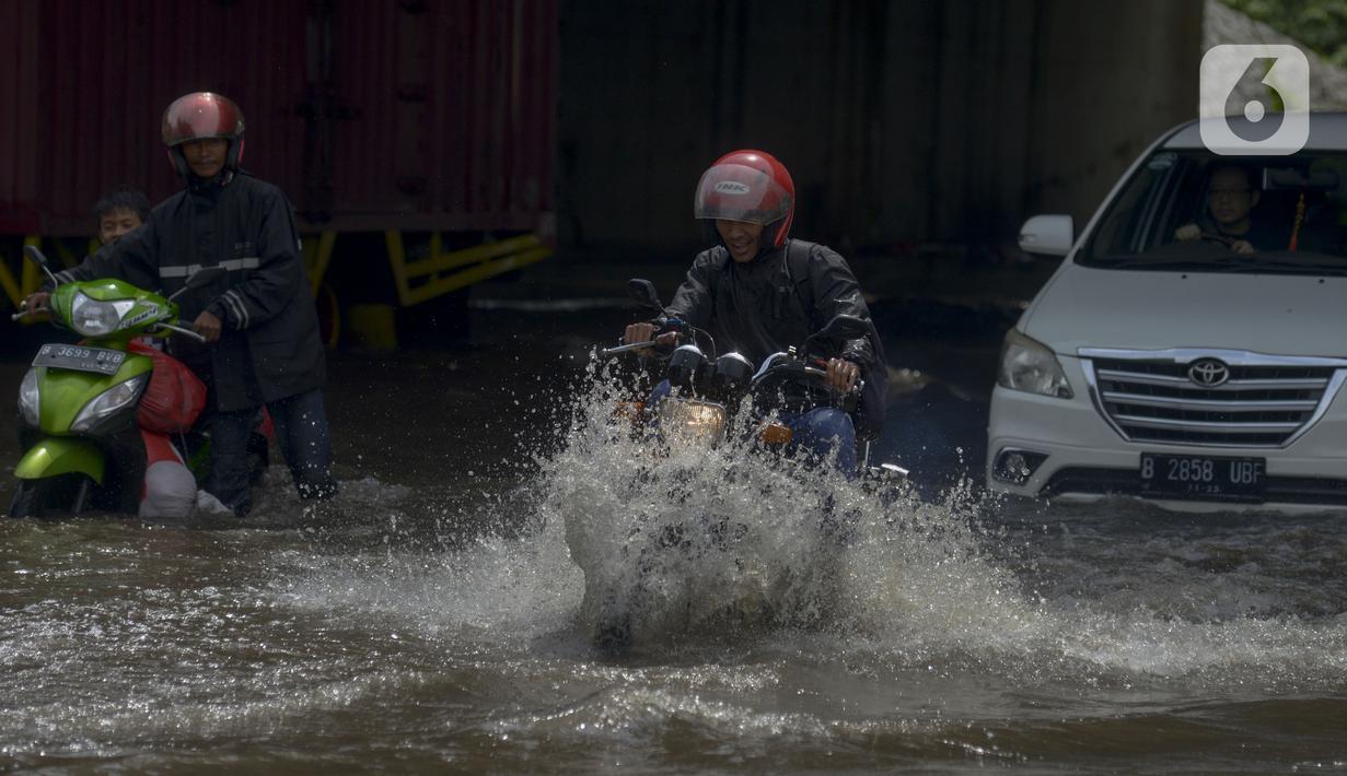 Pengendara motor menerobos banjir di Jalan Husein Nastranegara Perapatan Rawa Bokor, Tangerang, Sabtu (1/2/2020). Hujan deras yang mengguyur sejak Jumat (31/1) malam menyebabkan sejumlah kawasan di Tangerang terandam air. (merdeka.com/Imam Buhori)