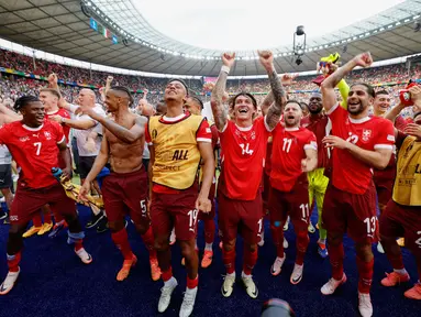 Pemain Swiss melakukan selebrasi setelah memastikan diri lolos ke babak perempat final dengan menumbangkan Italia pada babak 16 besar Euro 2024 di Olympiastadion Berlin, Sabtu (29/6/2024). (AFP/Axel Heimken)