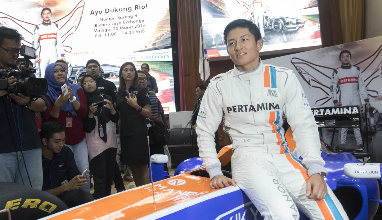 Pebalap F1 asal Indonesia, Rio Haryanto, berpose bersama replika mobil Manor Racing di Jakarta, Senin (14/3/2016). (Bola.com/Vitalis Yogi Trisna)