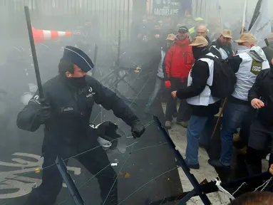 Polisi dan Demonstran terlibat bentrok saat aksi menolak Reformasi Pensiun di Brussels, Belgia, Selasa (15/11). Mereka menolak rencana pemerintah yang akan menaikkan usia pensiun dari 56 menjadi 63 tahun. (REUTERS / Yves Herman)