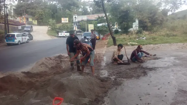 Sejumlah tukang tengah melakukan perbaikan pembuatan pos gatur polres Garut di jalur Kadungora