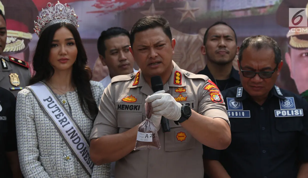 Kapolres Jakarta Barat Kombes Pol Hengki Haryadi (tengah) menunjukkan bahan pembuat narkoba saat rilis di sebuah perumahan di Pondok Rajeg, Cibinong, Senin (24/9). Polisi juga menyita 158 gram sabu, 3000 pil ekstasi. (Liputan6.com/Helmi Fithriansyah)