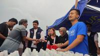 Tom Liwafa membagikan BBM untuk nelayan Surabaya. (Dian Kurniawan/Liputan6.com)