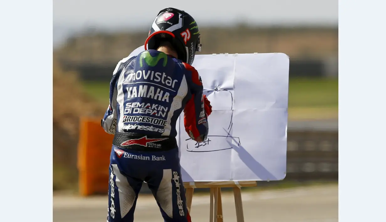 Jorge Lorenzo merayakan kemenangan dengan menulis di papan tulis dalam MotoGP Aragon, Spanyol, Minggu (27/9/2015). (Reuters/Marcelo del Pozo)
