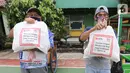 Warga terdampak Covid-19 menunjukkan paket makanan yang diterima di Cipulir, Jakarta Jumat (18/12/2020). Bantuan yang diberikan kepada pekerja sektor informal menjadikan total donasi yang diberikan DBS Group untuk Indonesia sebesar IDR27,2 miliar. (Liputan6.com/Fery Pradolo)