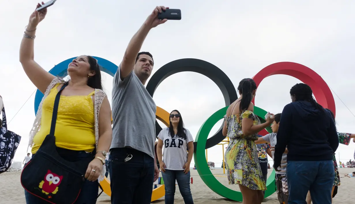 Warga berfoto di depan ring olimpiade di pantai Copacabana, Rio de Janeiro, jelang diselenggarakannya Olimpiade Rio 2016, (30/7/2016) 