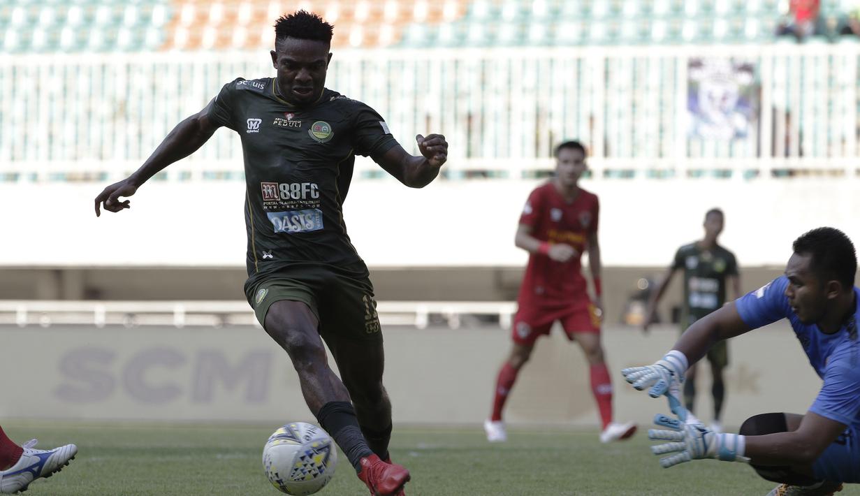 Gelandang Tira Persikabo, Osas Saha, berusaha melewati kiper Kalteng Putra, Dimas Galih, pada laga Shopee Liga 1 di Stadion Pakansari, Bogor, Jumat (26/7). Tira Persikabo menang 5-2 atas Kalteng. (Bola.com/Yoppy Renato)