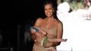 Model Mara Martin berjalan di atas runway sambil menyusui bayinya mengenakan pakaian renang Sports Illustrated pada Miami Swim Week 2018 di Florida, Minggu (15/8). Sang bayi mengenakan headphone untuk mengurangi suara bising dan musik. (AP/Lynne Sladky)