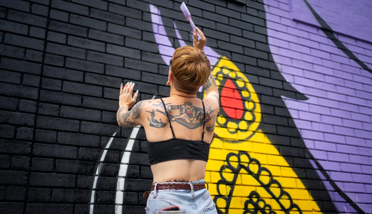 Nikki, asisten seniman Hatecopy, melukis pada dinding saat Festival Mural Montreal di Quebec, Kanada, 16 Juni 2022. Pada bulan Juni ini, lusinan seniman sibuk melukis pada dinding raksasa dalam edisi kesepuluh Festival Mural Montreal. (Paola Chapdelaine/AFP)