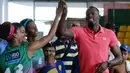 5.	Sprinter Jamaika juara Olimpiade,Usain Bolt, akrab dengan anak-anak saat mengunjungi kompleks olah raga Mangueira, Rio de Janeiro, Brasil. Jumat (16/4)