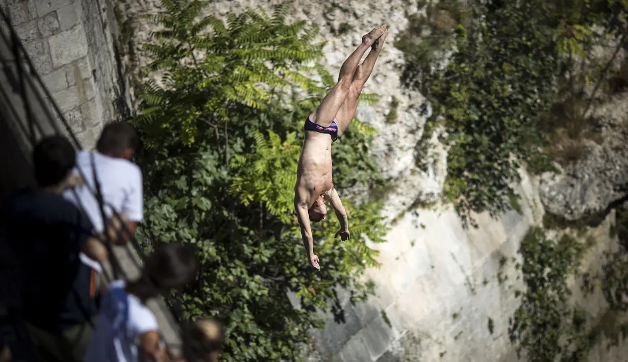 Penonton tengah menyaksikan atlet asal AS, David Colturi beraksi menaklukan jarak 27,5 meter pada ajang Red Bull Cliff Diving World Series di Mostar, Bosnia and Herzegovina, (23/9/2016).  (AFP/RED BULL/Romina Amato)