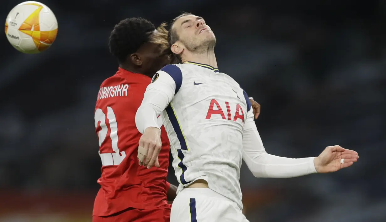 Penyerang Tottenham Hotspur, Gareth Bale bertarung memperebutkan bola dengan bek Royal Antwerp, Dylan Batubinsika pada matchday terakhir Grup J Liga Europa di Tottenham Hotspur Stadium, Jumat (11/12/2020) dinihari WIB. Tottenham mengalahkan Royal Antwerp 2-0. (AP/Kirsty Wigglesworth, pool)