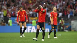 Sergio Ramos (tengah) menutup wajahnya usai kalah dari Rusia pada laga 16 besar Piala Dunia 2018 di Luzhniki Stadium, Moskow, Rusia, (1/7/2018). Spanyol kalah adu penalti 3-4. (AFP/Francisco Leong)