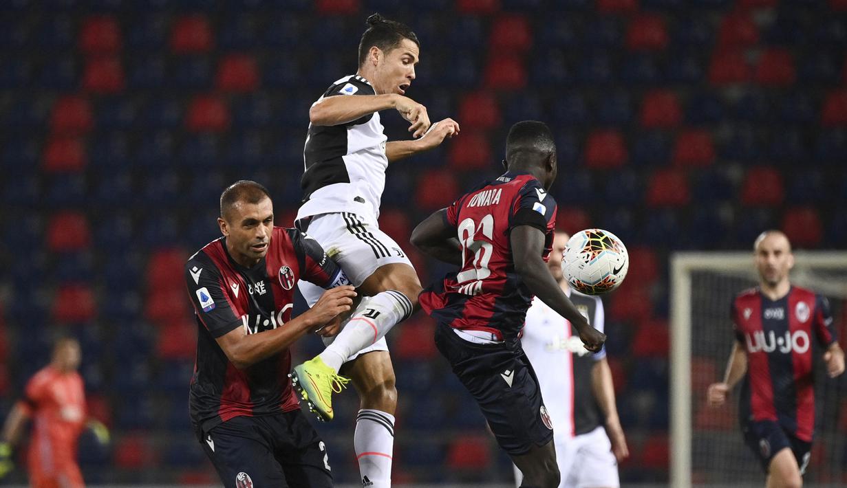 Striker Juventus, Cristiano Ronaldo, berebut bola dengan pemain Bologna, Danilo dan Musa Juwara pada laga Serie A di Stadion Renato Dall'Ara, Senin (22/6/2020). Juventus menang 2-0 atas Bologna. (AP/Massimo Paolone)