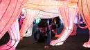 Dua bocah bermain di dekat seni instalasi cahaya yang berjudul "Halo Park" di Chaoyang Park, Beijing (7/5). Dalam pameran ini lebih dari 20 hiburan visual acousto-optik ditampilkan. (AFP/Fred Dufour)