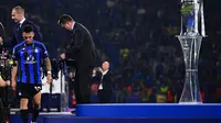 Lautaro Martinez berjalan lesu di samping trofi Liga Champions. Inter Milan hanya runner up usai kalah 0-1 dari Manchester City (AFP)