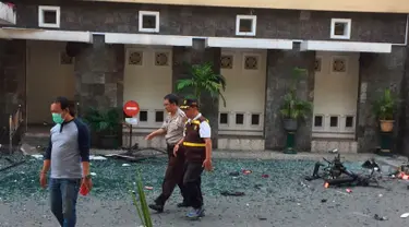 Petugas kepolisian berjalan melewati puing-puing pascaledakan bom di Gereja Santa Maria, Surabaya, Minggu (13/5). Selain di Gereja Katolik Santa Maria, dua ledakan lain di Gereja Pantekosta Pusat Surabaya dan Gereja Kristen Jawi Wetan. (AP/Trisnadi)