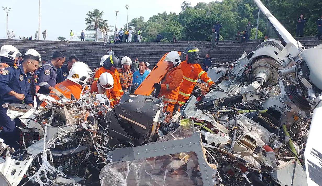 Foto yang dirilis pada tanggal 23 April 2024 oleh Departemen Pemadam Kebakaran dan Penyelamatan Perak ini menunjukkan tim penyelamat memeriksa lokasi kecelakaan setelah dua helikopter militer bertabrakan di Lumut, negara bagian Perak, Malaysia. (Handout/Departemen Pemadam Kebakaran dan Penyelamatan Perak/AFP)