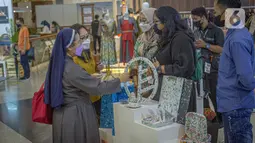 Pengunjung melihat produk kerajinan yang terpajang di salah satu stan pada pameran Inacraft 2022 di Balai Sidang Jakarta Convention Center (JCC), Rabu (23/3/2022). Setelah dua tahun vakum, Inacraft kembali diselenggarakan secara hybrid hingga 27 Maret 2022 mendatang. (Liputan6.com/Faizal Fanani)