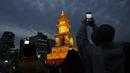 Umat Buddha Korea Selatan mengenakan masker memegang smartphone mereka selama upacara pencahayaan untuk merayakan ulang tahun Buddha yang akan datang pada 8 Mei, di Seoul, Korea Selatan (5/4/2022). (AP Photo/Lee Jin-man)