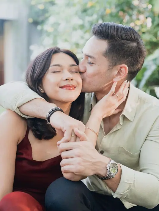 Di sini, Nana Mirdad tampil memesona dibalut dress bertali spageti berwarna burgundy, bermesraan dengan sang suami yang mengenakan kemeja lengan panjang berwarna sage dan celana panjang hitam. [Foto: Instagram/nanamirdad_]