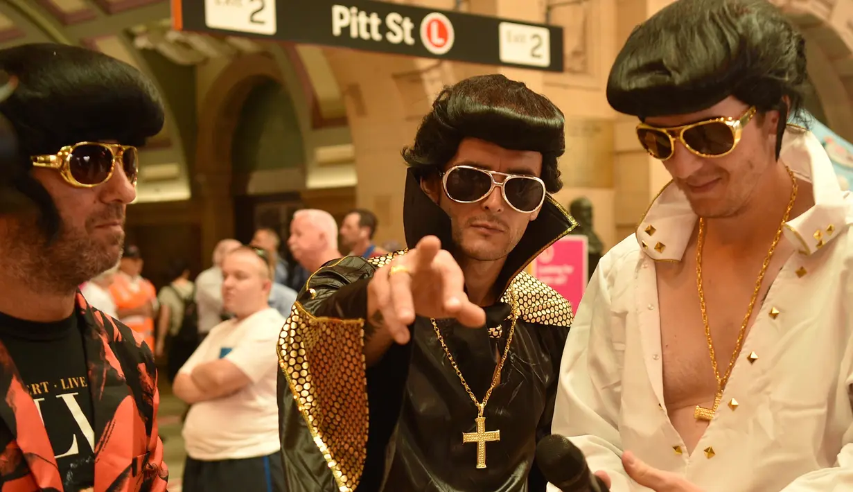 Sejumlah penggemar Elvis mengenakan kostum berpose saat berfoto bersama sebelum naik kereta ke The Parkes Elvis Festival, di Sydney (11/1). (AFP Photo/Peter Parks)
