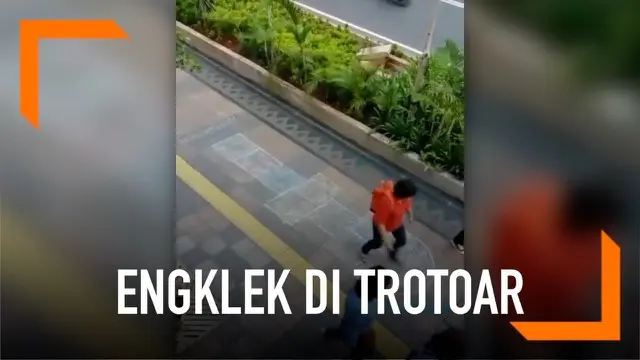 Para pejalan kaki di Jalan Sudirman, Jakarta mendadak bermain engklek. Hal ini terjadi karena trotoar digambari kotak bermain.