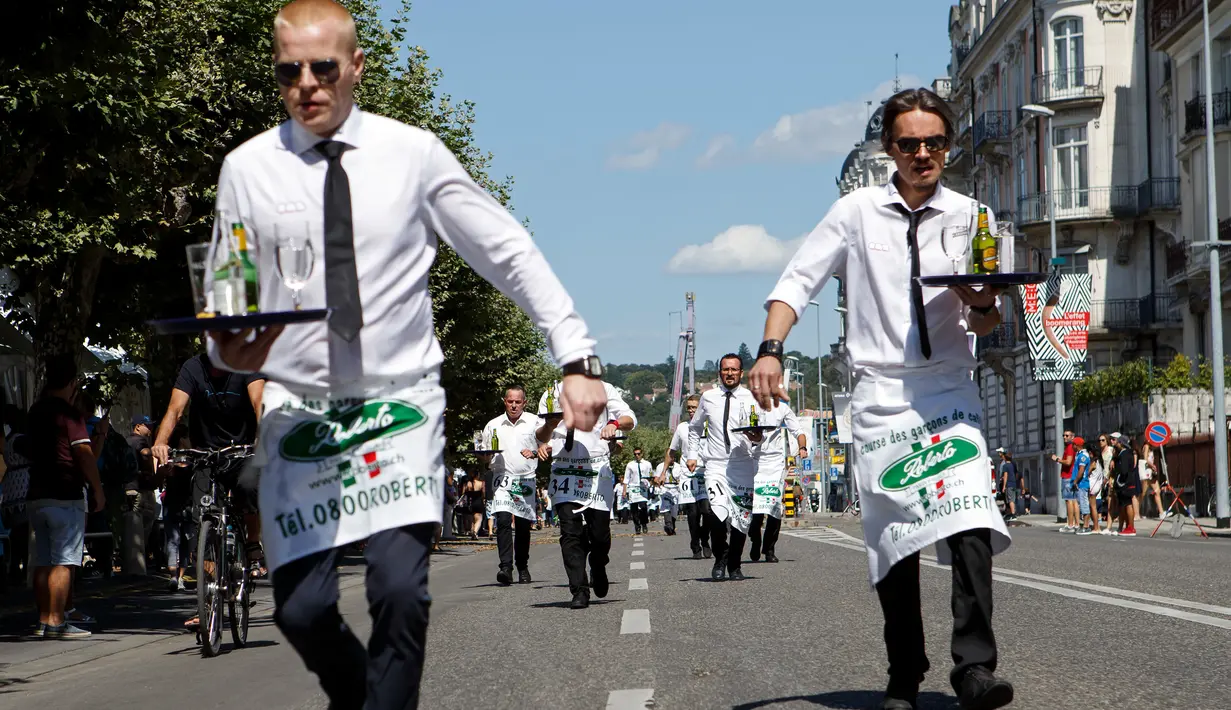 Sejumlah pramusaji beradu ketangkasan dalam Waiters Race ke-21 di Fetes de Geneve, Swiss, 6 Agustus 2017. Peserta diminta unjuk kebolehan menggunakan satu tangan membawa nampan berisi dua gelas dan dua botol penuh air. (Salvatore Di Nolfi/Keystone via AP)
