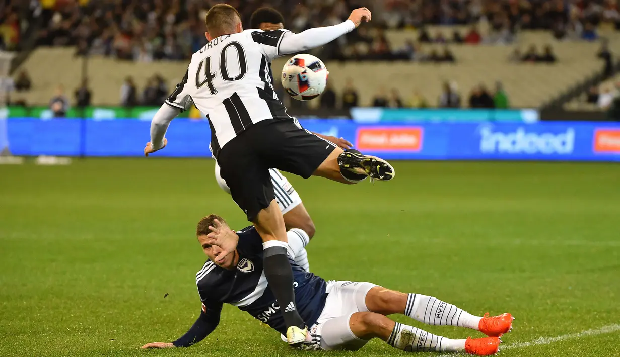 Pemain Juventus, Pol Lirola melompat menghindari terjangan pemain Melbourne Victory, Mitchell Austin pada ajang International Champions Cup football di Melbourne, (23/7/2016). (AFP/Paul Crock)