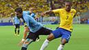 Bek Uruguay, Jorge Fucile, berebut bola dengan gelandang Brasil, Douglas Costa, pada kualifikasi Piala Dunia 2018 di Recife, Brasil, Sabtu (26/3/2016) pagi WIB. Bagi Uruguay, hasil ini membuat mereka tetap di peringkat dua. (AFP/Christophe Simon)