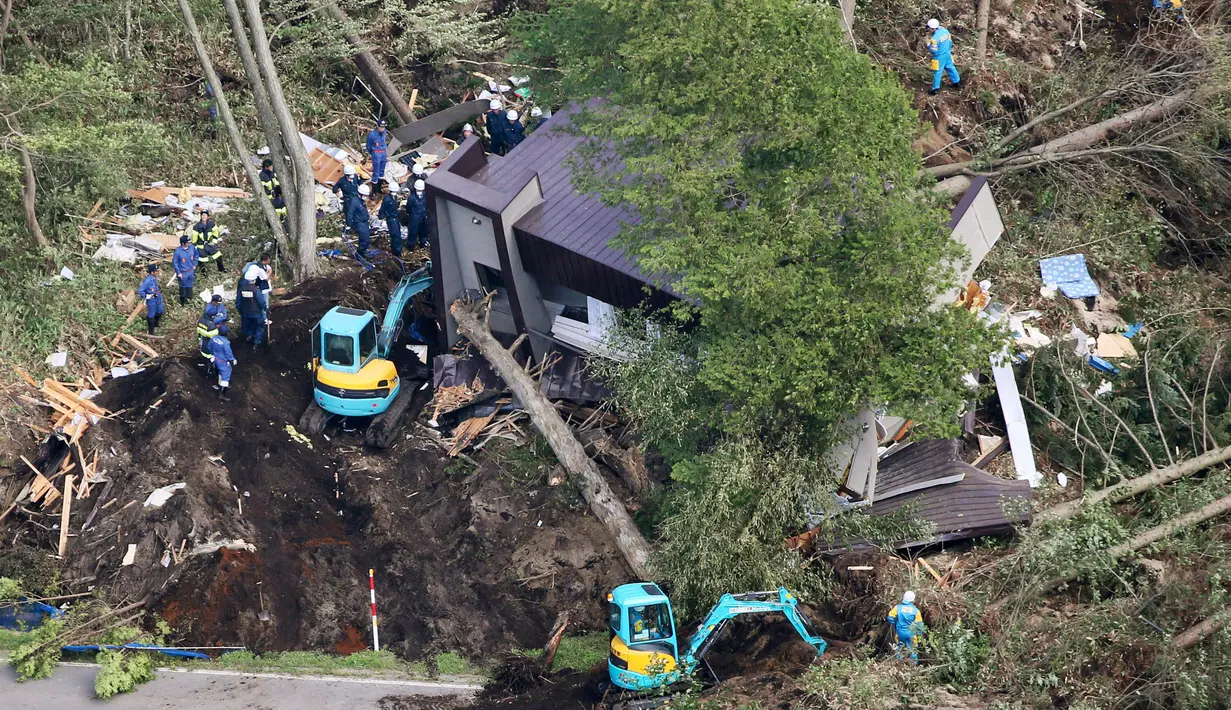 Tim penyelamat mencari orang hilang setelah gempa dan tanah longsor terjadi di Kota Atsuma, Prefektur Hokkaido, Jepang, Kamis (6/9). PM Shinzo Abe mengatakan 25 ribu tentara dan personel lainnya dikirim untuk penyelamatan. (Kyodo News via AP)