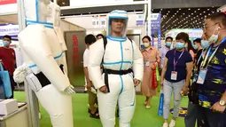 Seorang pengunjung menjajal pakaian pelindung di pameran peralatan medis di Zhengzhou, Provinsi Henan, China tengah (4/8/2020). Pameran yang berlangsung selama tiga hari itu digelar di Zhengzhou pada Selasa (4/8) dan diikuti oleh lebih dari 1.000 peserta dari seantero China. (Xinhua/Zhu Xiang)
