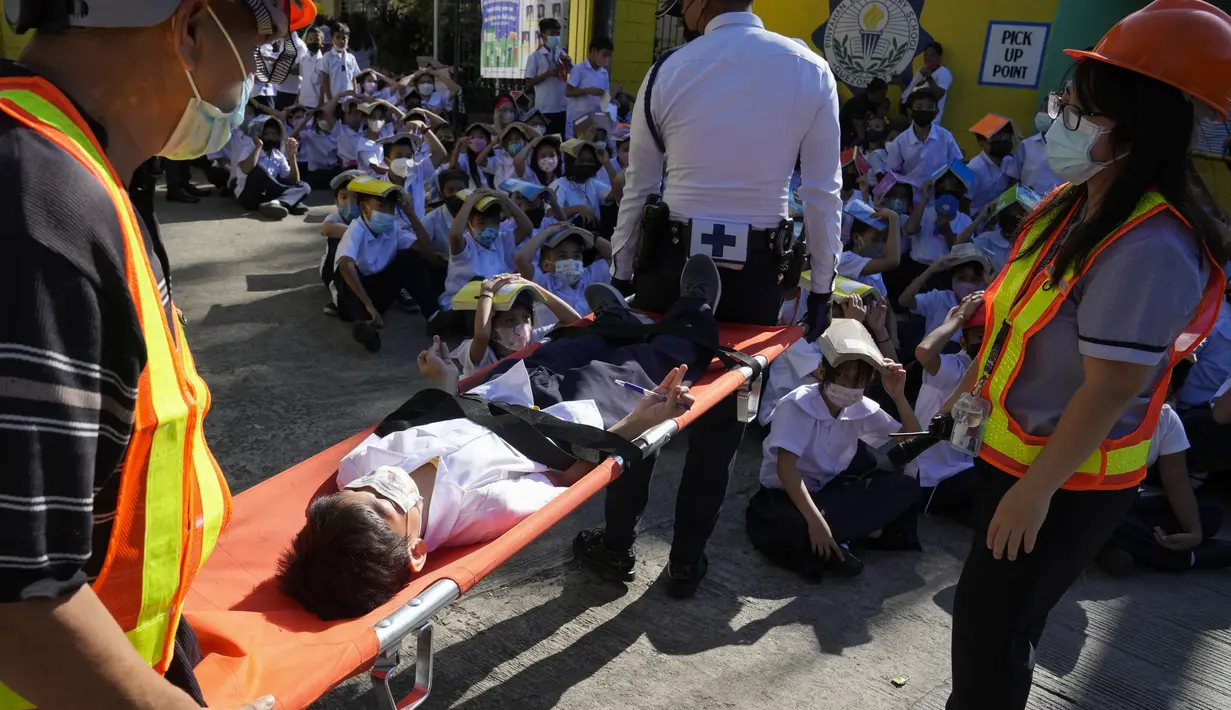 <p>Seorang siswa digendong dengan tandu selama latihan gempa di sebuah sekolah dasar di Metro Manila, Filipina, Kamis (8/9/2022). Filipina melakukan latihan gempa nasional kuartal ketiga sebagai bagian dari upaya untuk membuat publik mengetahui protokol dan tanggapan selama bencana. (AP Photo/Aaron Favila)</p>