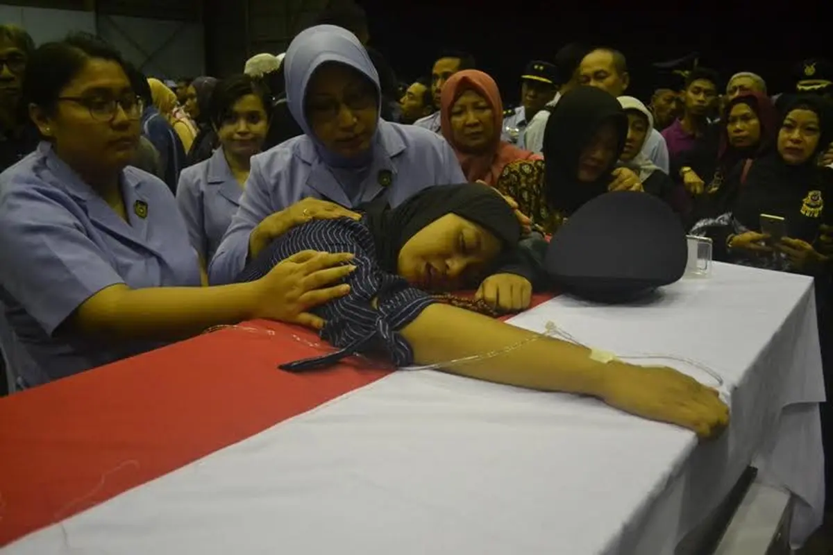 Istri korban pesawat Hercules jatuh di Wamena memeluk peti jenazah suaminya. 